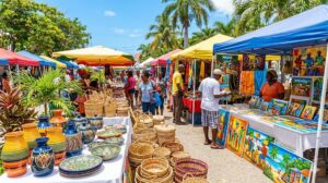A colorful outdoor Caribbean craft market selling handmade goods and pottery.